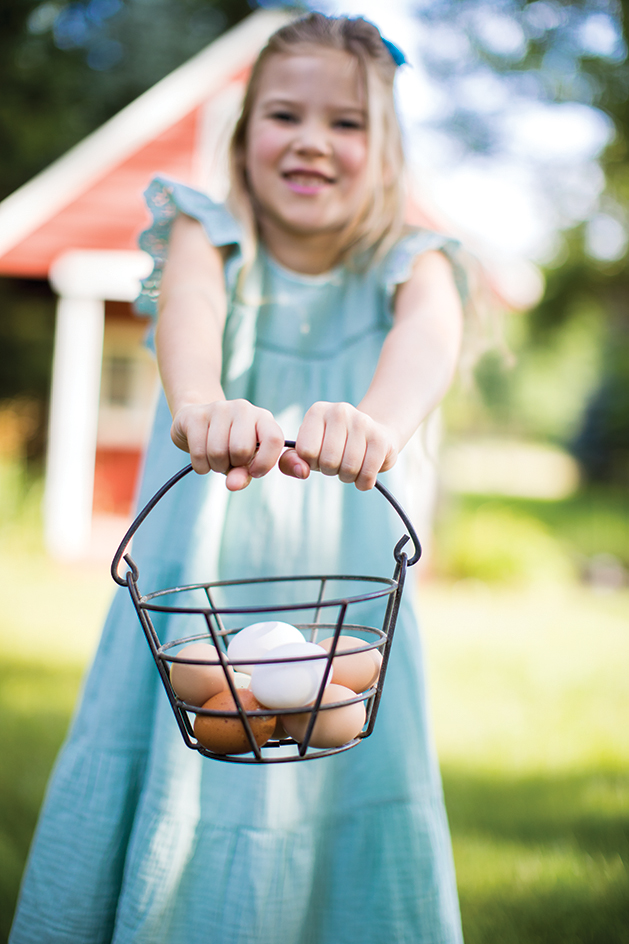 Young Girl Holding Basket of Eggs