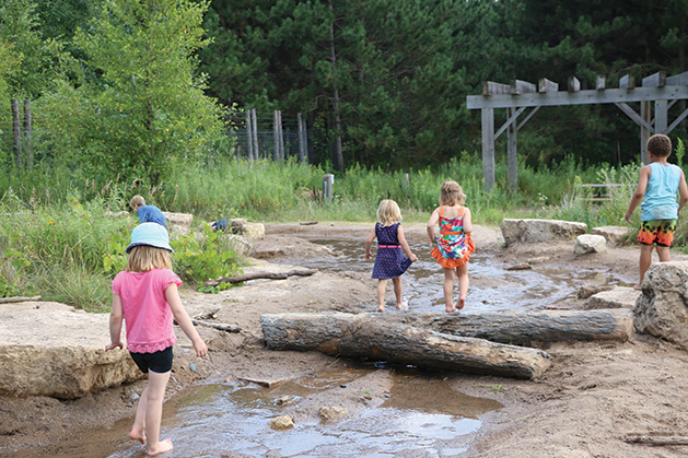 Children walk in the water at Tamarack Nature Center.