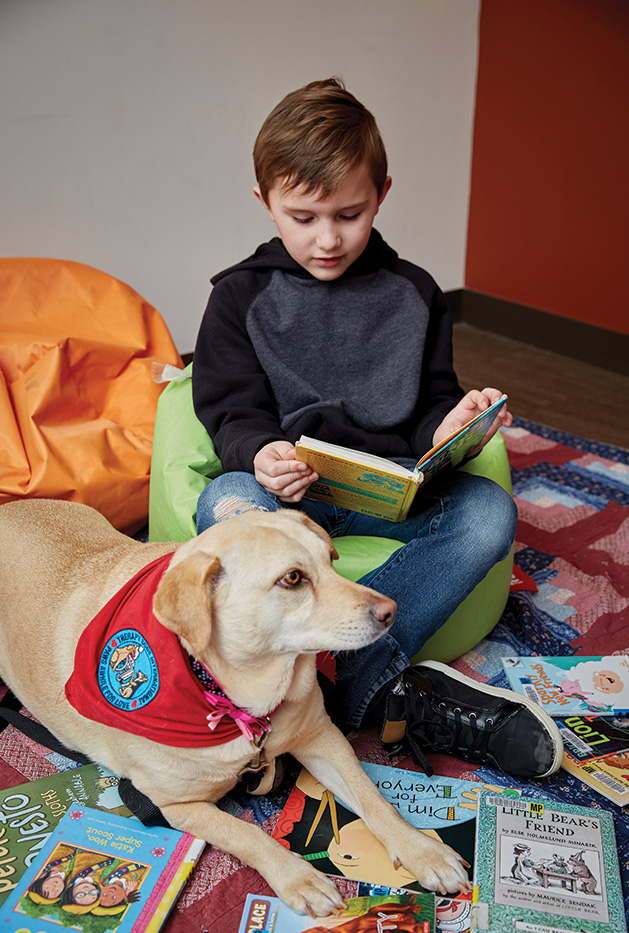 A child reads to a dog during the Paws to Read program