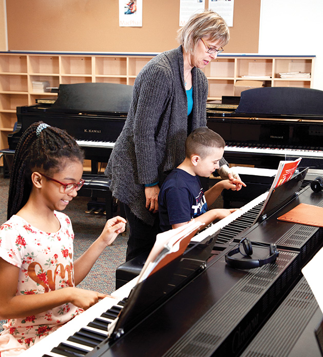 Two children take piano lessons through a partnership with the MacPhail Center for Music.
