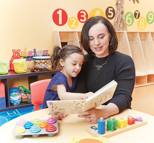 Leah Retamozo reads to a child at Bilingual Child Care & Education Center.