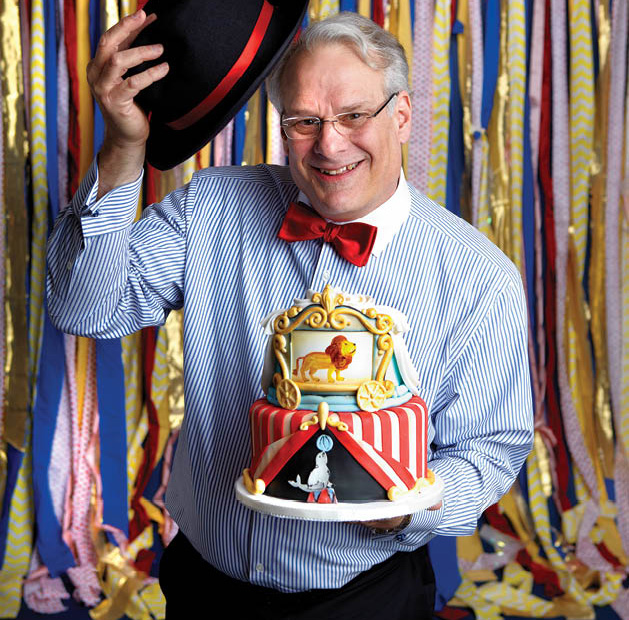 John Lupo, owner of Grandma’s bakery, with a custom circus-themed cake.