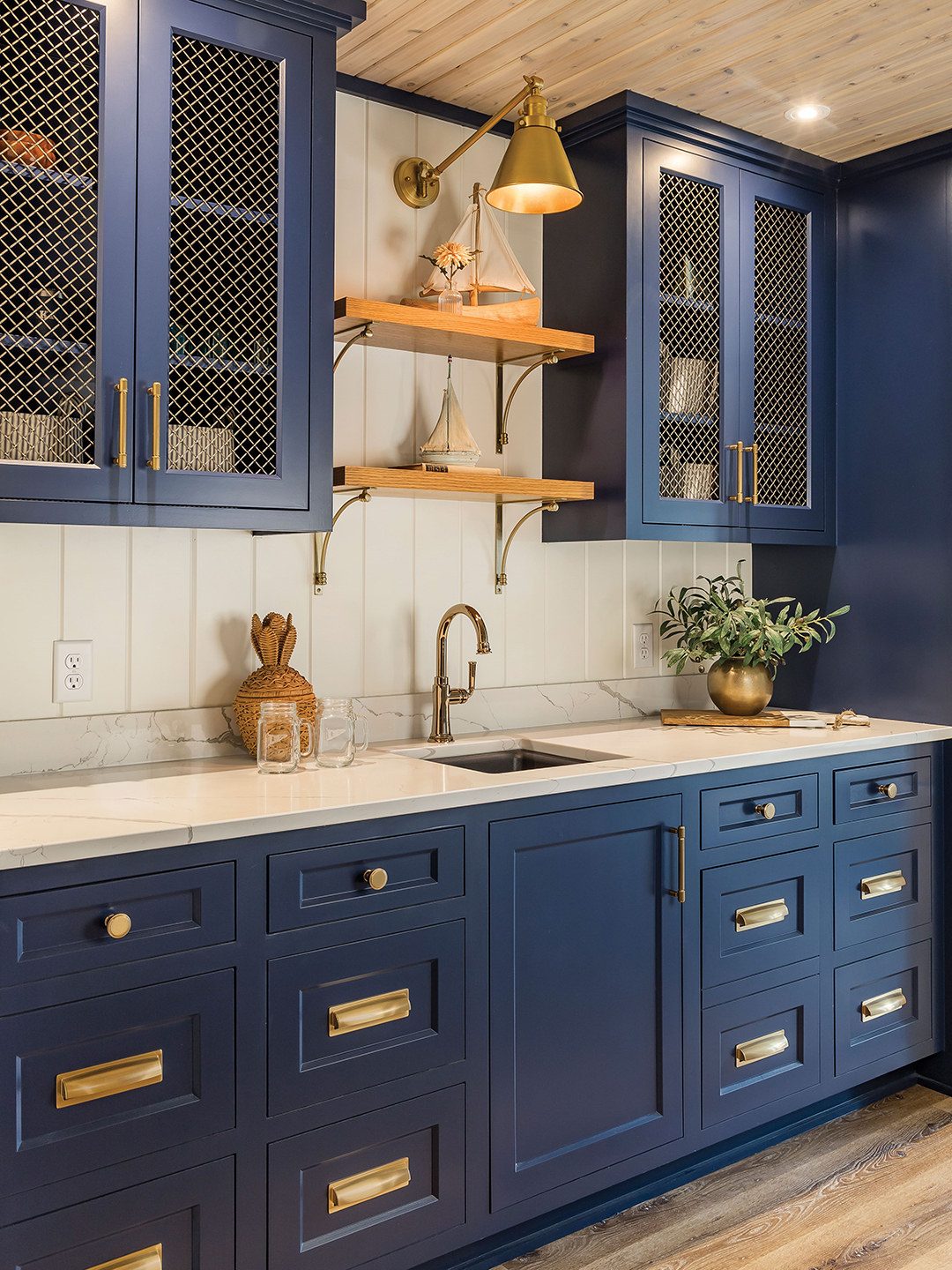 The design of the lower level bar area nods to White Bear Yacht Club, with deep blue cabinets and brass accents. 