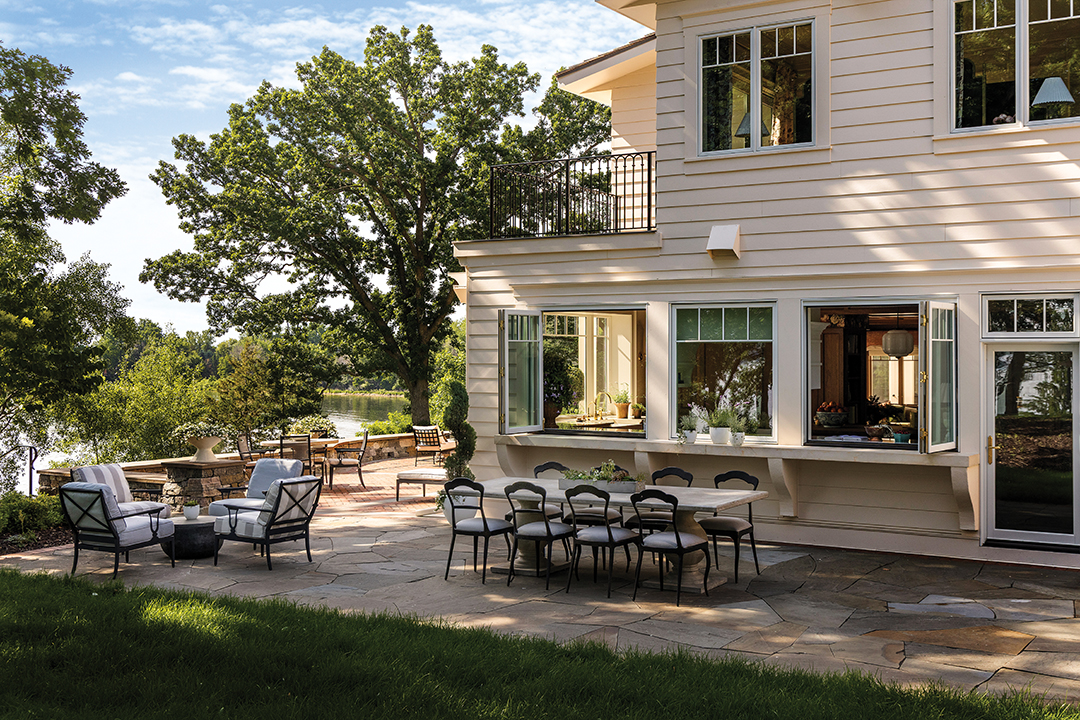The formerly enclosed lakeside porch was torn down and replaced with an expansive outdoor entertaining area, featuring a hot tub and fire pit overlooking the lake. “We do a big Fourth of July party every year, and [the outdoor space] was so much more functional this year,” homeowner Anna Shroyer says. One of her favorite new additions is a serving countertop that extends from the kitchen. “We can open the kitchen windows and actually just serve food right onto the countertop outside,” she says.