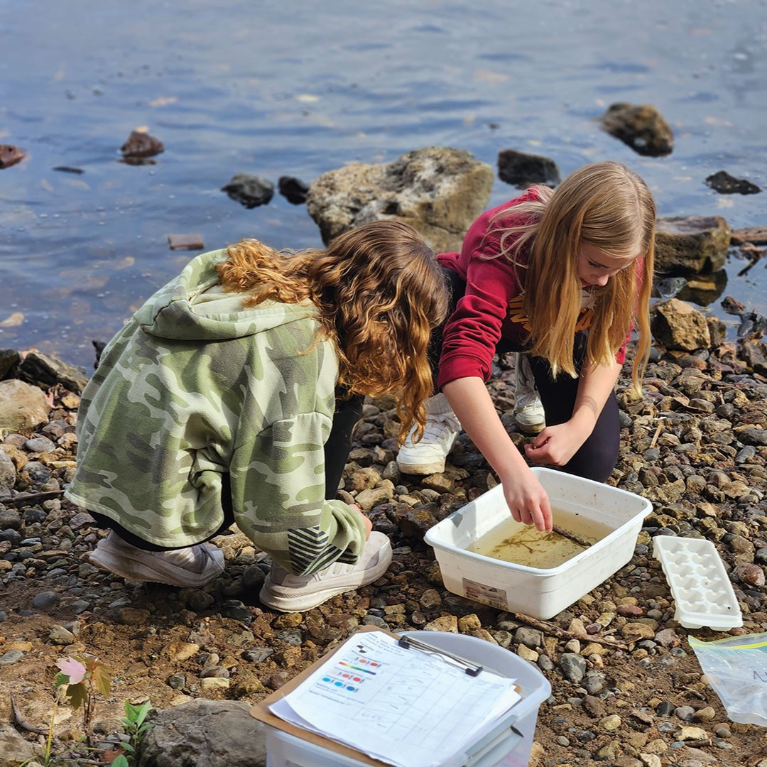 Two girls look for aquatic insects at Carpenter Nature Center
